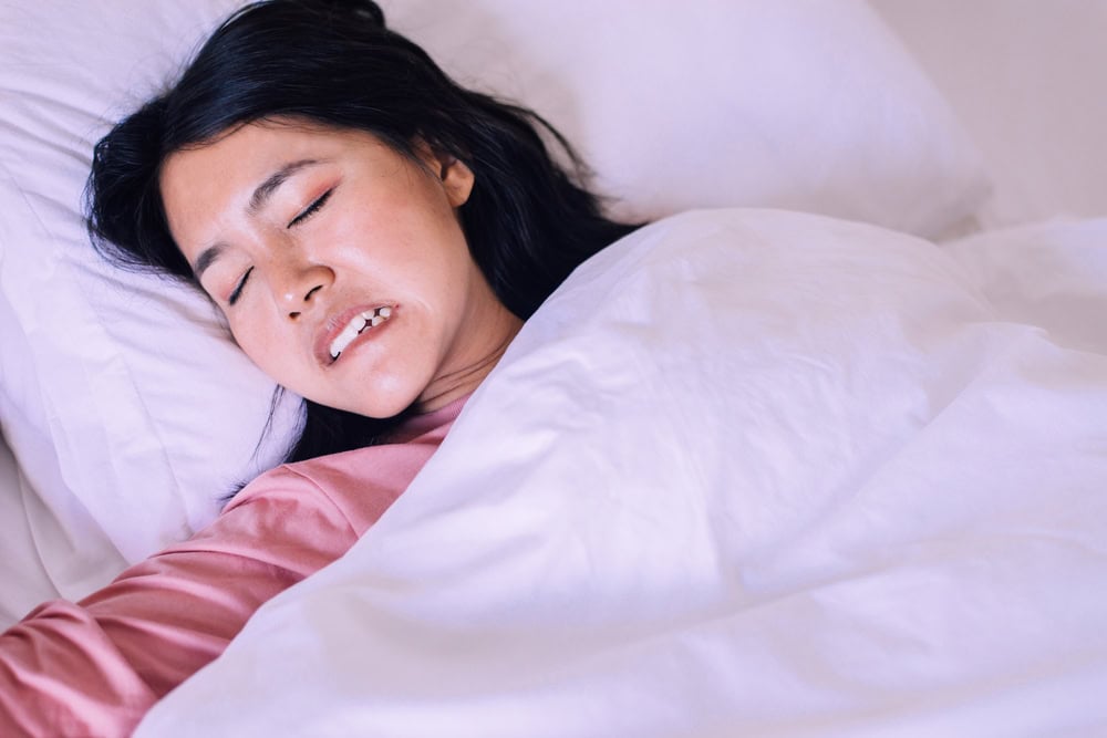 Woman tosses and turns at night while grinding her teeth