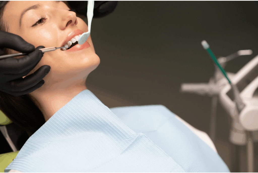 Patient receiving professional dental cleaning at Manassra Dental, with dentist using tools to gently clean and polish teeth.