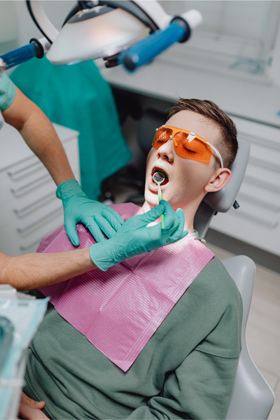 Young patient wearing protective eyewear receiving comfortable dental treatment with modern technology at Manassra Dental San Jose
