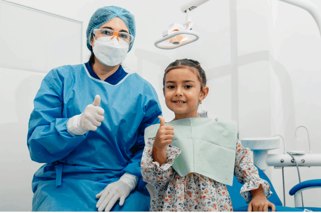 A cheerful young female patient giving a thumbs-up alongside a smiling dental professional, symbolizing **comfortable, comprehensive care** for the entire family at Manassra Dental in San Jose, CA.