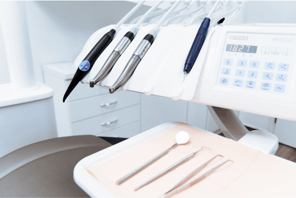 A tray of sterile dental instruments and handpieces next to the control panel, representing the readiness of the professional equipment during **regular office hours** at Manassra Dental in San Jose.