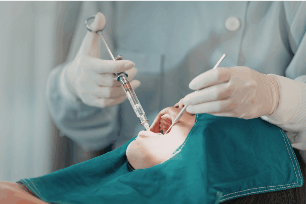 Dentist administering local anesthetic or sedation to a patient to ensure a comfortable and pain-free procedure at Manassra Dental in San Jose.