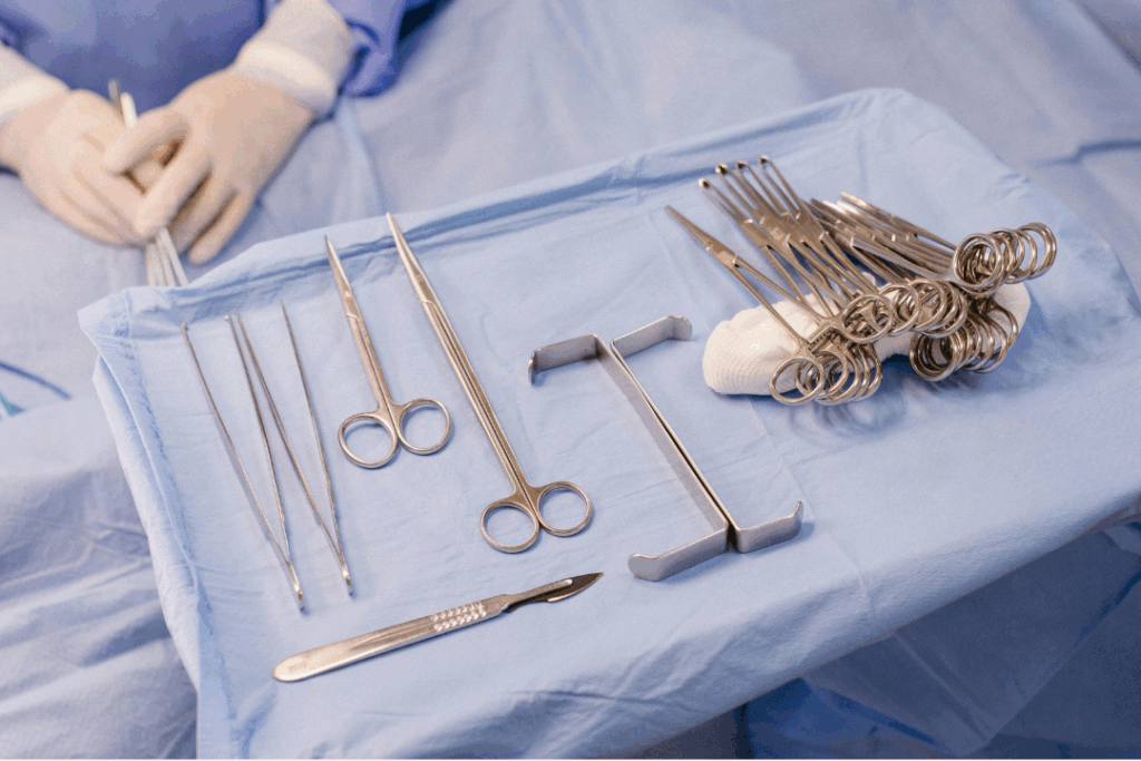 Sterile surgical instruments, including scalpels and forceps, laid out for a **surgical tooth extraction** procedure at Manassra Dental in San Jose.