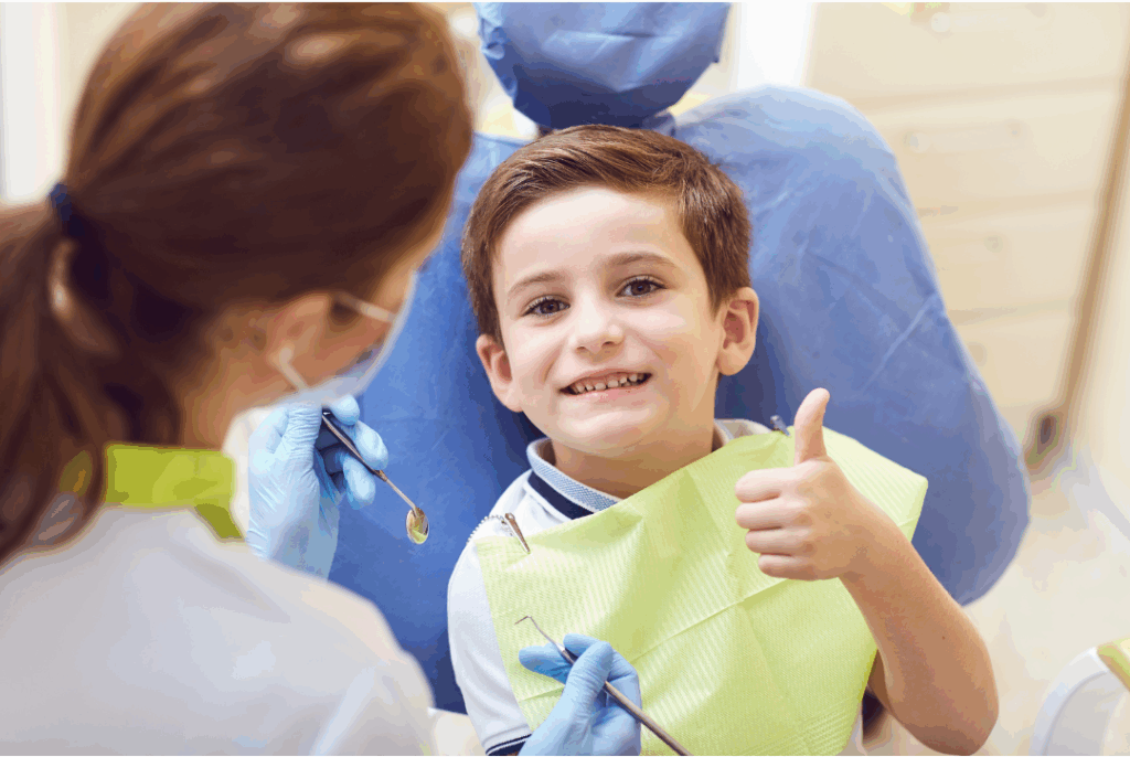 Happy young boy giving a thumbs-up after a successful and gentle **pediatric dental cleaning**, promoting a lifetime of healthy habits at Manassra Dental in San Jose.