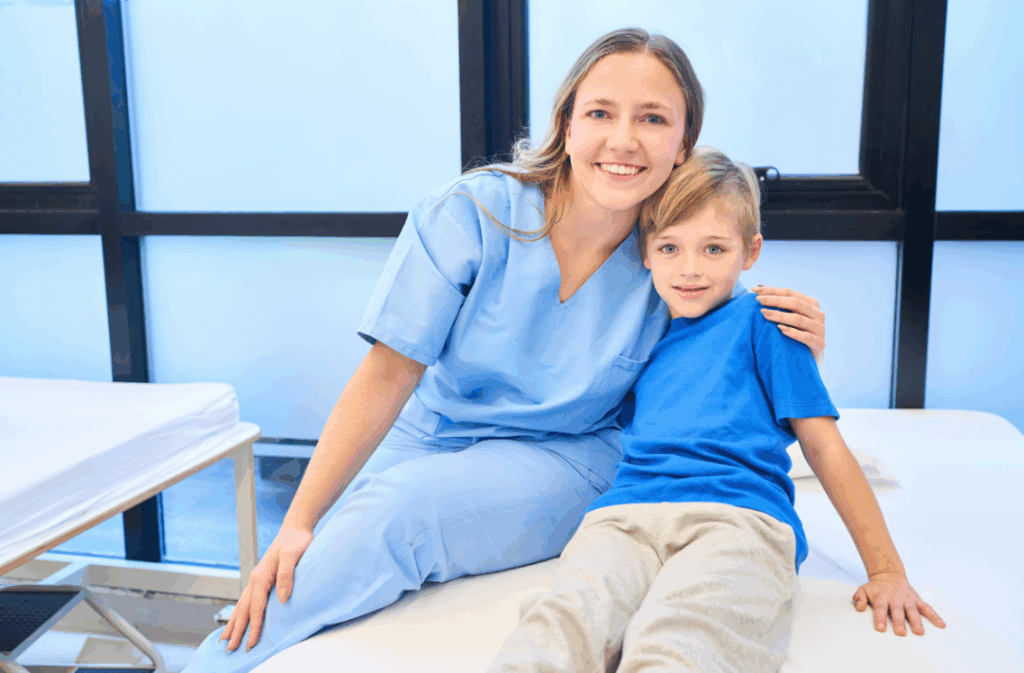 A caring dental assistant or hygienist sitting next to a happy, relaxed young patient, highlighting safe and comfortable **pediatric fillings** at Manassra Dental in San Jose.