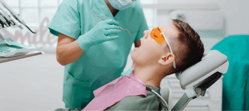 Periodontist in San Jose performing a precise oral examination with magnifying loupes, highlighting expert **Periodontic** care for optimal **oral health** at Manassra Dental.