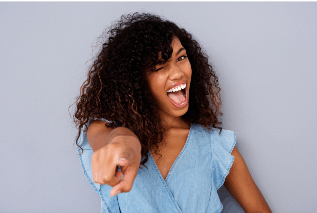 Happy, healthy woman winking, symbolizing the benefits of good oral health on overall **whole-body wellness** and emphasizing **The Link Between Gum Health and Whole-Body Wellness** at Manassra Dental in San Jose.