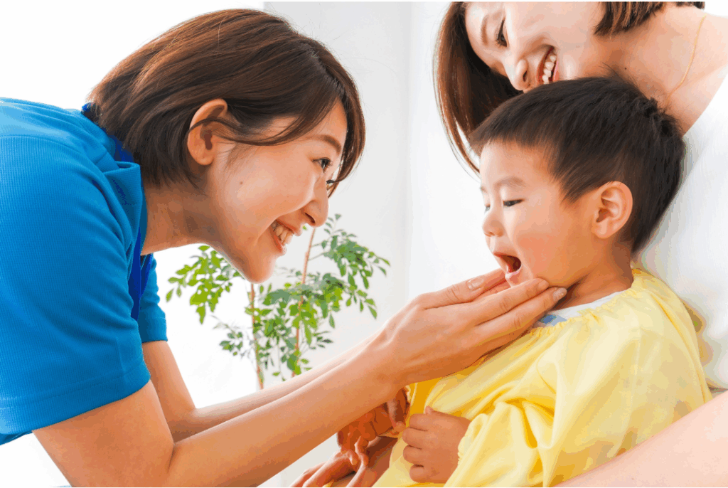 Caring dental professional examining a young boy's mouth with the mother present, illustrating the importance of early intervention and **Space Maintainers** for proper dental development in San Jose.