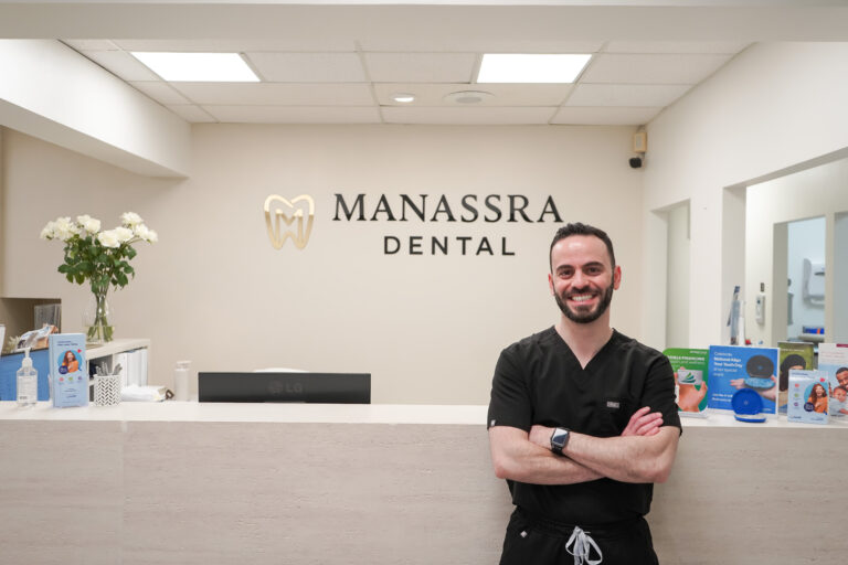 Dr. Manassra posing in the dental office, representing professional and patient-focused dental care.