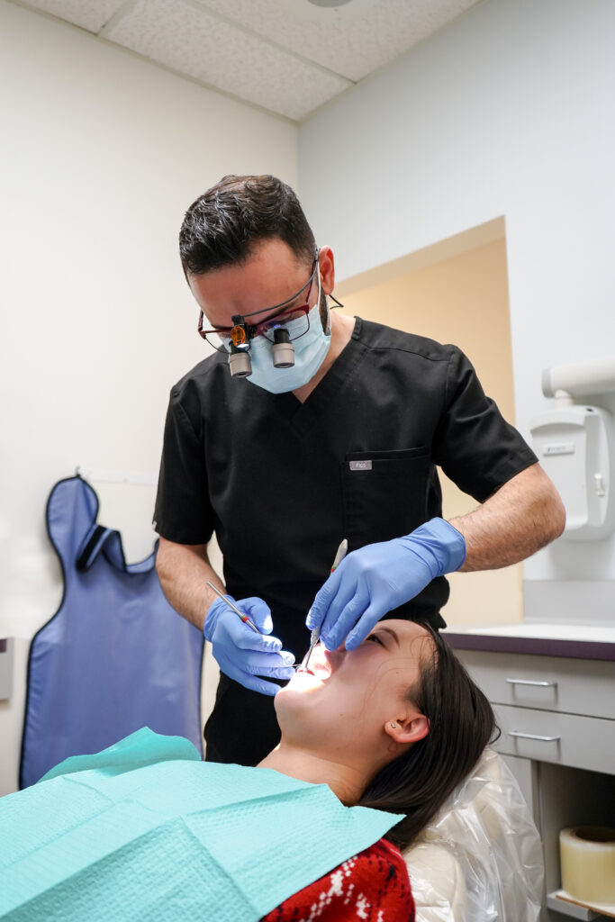 “Dr. Manassra providing dental treatment to a patient at Manassra Dental.”