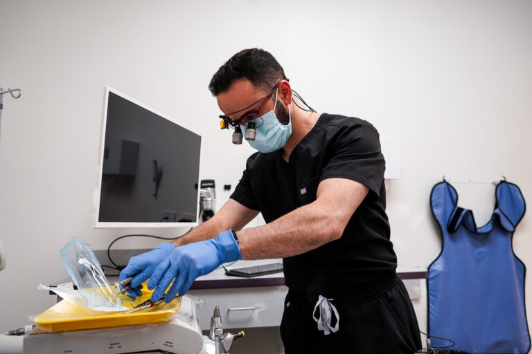 Dr. Ahmed performing dental treatment at Manassra Dental, providing professional patient care.