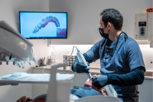 A patient at Manassra Dental undergoing a safe 3D CBCT scan while wearing a protective lead apron.