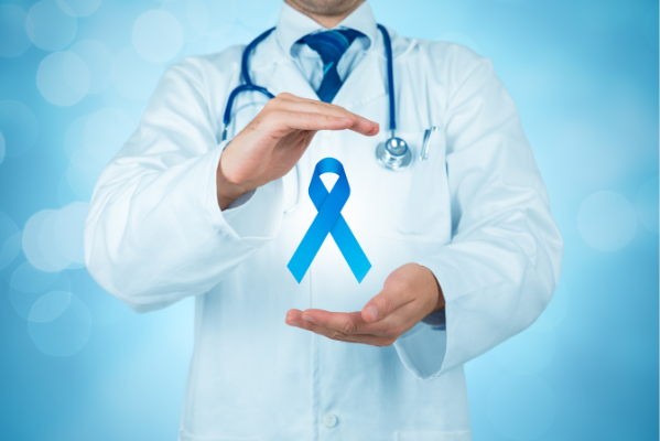 A medical professional in a white coat holding a blue awareness ribbon, representing oral cancer screening services at Manassra Dental.