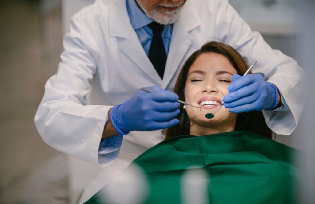 A dentist examining a patient's smile with a mouth mirror and explorer.