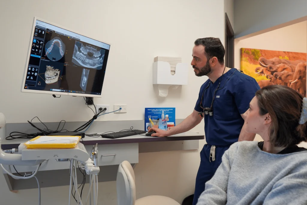 San Jose dentist reviewing 3D CBCT imaging and digital tooth scans on a computer screen with a patient at Manassra Dental.